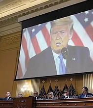 Former President Donald Trump is shown on a screen as the House select committee investigating the Jan. 6 attack holds its final meeting Dec. 19 on Capitol Hill.