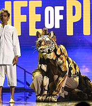 Hiran Abeysekera (left) performs alonside the several puppeteers who power Richard Parker the Bengal Tiger at the 2022 Olivier Awards.
Mandatory Credit:	Jeff Spicer/Getty Images