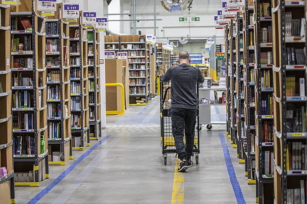 Amazon will lay off 17,000 employees according to the Wall Street Journal, citing unnamed sources. A worker pushes a cart laden with ordered items among shelves at an Amazon warehouse in November of 2021 in Brieselang, Germany.
Mandatory Credit:	Maja Hitij/Getty Images