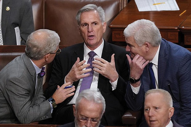 Rep. Patrick McHenry, R-N.C., left, and Rep. Tom Emmer, R-Minn., right, speaks with Rep. Kevin McCarthy, R-Calif., in the House chamber as the House meets for a second day to elect a speaker and convene the 118th Congress in Washington on Jan. 4.
