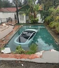 A Tesla driver in Pasadena drove through a wall and landed in a pool on January 10, authorities said. Three people in the car, including a child, were rescued by Good Samaritans.
Mandatory Credit:	Pasadena Fire Department/KABC