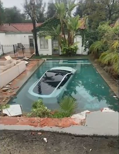 A Tesla driver in Pasadena drove through a wall and landed in a pool on January 10, authorities said. Three people in the car, including a child, were rescued by Good Samaritans.
Mandatory Credit:	Pasadena Fire Department/KABC