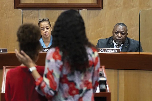Djifa Lee, a second grade teacher at Saunders Elementary, center, stands with her daughter as she speaks in front of the Newport News School Board at the Newport News Public Schools Administration building Tuesday. Community members spoke about issues and solutions to violence in schools following the shooting at Richneck Elementary by a 6-year-old that left a teacher in critical condition.