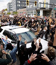 Ohio State students surround a police vehicle on April 21, 2021, while marching toward the Ohio Statehouse to protest the police shooting that killed Ma'Khia Bryant.
Mandatory Credit:	Kyle Robertson/Columbus Dispatch/USA Today Network