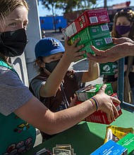 It's Girl Scout cookie season again. Two young girls sell Girl Scout cookies in Los Angeles on February 11, 2022.
Mandatory Credit:	Francine Orr/Los Angeles Times/Getty Images