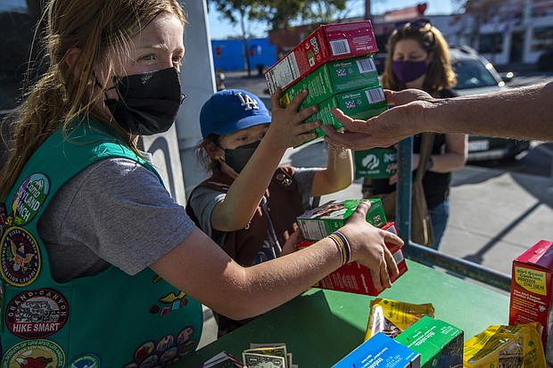 It's Girl Scout cookie season again. Two young girls sell Girl Scout cookies in Los Angeles on February 11, 2022.
Mandatory Credit:	Francine Orr/Los Angeles Times/Getty Images