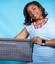 Clarice Phelps poses in 2020 with the chart used to organize the building blocks of science.
Mandatory Credit:	Calvin Mattheis/The Knoxville News Sentinel/USA Today Network