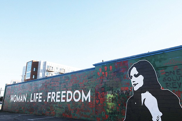 “Woman. Life. Freedom.,” a new mural painted on the side of a vacant car wash building at 1205 Arthur Ashe Blvd., shows support for protesters in Iran who are fighting in support of a young Iranian woman, Mahsa Jina Amini, pictured, who was wrongfully taken into custody by the Iranian police. She was in a coma for three days and died on Sept. 16, 2022. Her alleged crime? Ms. Amini, 22, was visiting the capital city of Tehran on vacation from another part of her country of Iran and the “Morality Police” arrested her because her hair was not properly secured under her hijab, a head covering worn by some Muslim women, explains Ari Abad, an Iranian-American who came to Richmond when she was 17. Ms. Abad later co-founded, Woman Life Freedom RVA, which led the local mural project