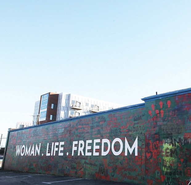 “Woman. Life. Freedom.,” a new mural painted on the side of a vacant car wash building at 1205 Arthur Ashe Blvd., shows support for protesters in Iran who are fighting in support of a young Iranian woman, Mahsa Jina Amini, pictured, who was wrongfully taken into custody by the Iranian police. She was in a coma for three days and died on Sept. 16, 2022. Her alleged crime? Ms. Amini, 22, was visiting the capital city of Tehran on vacation from another part of her country of Iran and the “Morality Police” arrested her because her hair was not properly secured under her hijab, a head covering worn by some Muslim women, explains Ari Abad, an Iranian-American who came to Richmond when she was 17. Ms. Abad later co-founded, Woman Life Freedom RVA, which led the local mural project