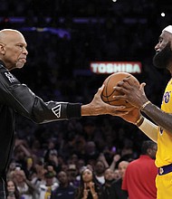 Kareem Abdul-Jabbar, left, hands a basketball to Los Angeles Lakers forward LeBron James after he passed Mr. Abdul-Jabbar to become the NBA’s all-time leading scorer during the second half of a Feb. 7 game against the Oklahoma City Thunder, in Los Angeles.