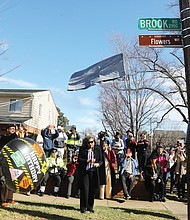 At the corner of Hammond and Brook Road in Richmond’s Edgehill neighborhood, Gary Flowers, left, pulls the signage cover strings Monday, as his sister, Jan Flowers, stands with him. Along with other family, friends and neighbors, the son and daughter of Stafford Alvin Flowers and Ella Lee Fountain Flowers unveil the honorary street sign, Flowers Way, that honors their father and mother.
Stafford Alvin Flowers, who died in 2011, was a brick mason and owner of a contracting business. He also was a co-founder of the Metropolitan Business League, and a regional director for the National Business League, which evolved from the Negro Business League founded by Booker T. Washington in 1900. Ella Lee Fountain Flowers, a former Virginia Union University and Richmond Public Schools educator, died May 15, 2022. Mrs. Flowers was an 80-year member of Delta Sigma Theta Sorority and a lifelong member of the NAACP, serving as the secretary for the Richmond Chapter.
The street dedication was initiated by 3rd District North Side City Council woman Ann-Frances Lambert, who wants the history of Black Northside Richmond locked in for all to know. She reminded people that a large percentage of Black Americans, when researching their genealogy, realize they have a connection to Richmond.