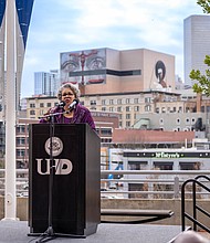 Rep. Senfronia Thompson, with the mural with her eyes in the background, speak at the Remembrance Murals unveiling event that also honored her for her public service.
