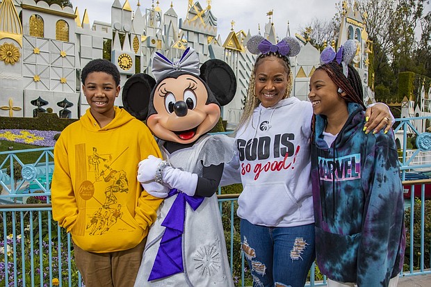 Award-winning singer and radio show host Erica Campbell and her family enjoy an unforgettable day at Disneyland Park in Anaheim, Calif., before she takes the stage as the headlining talent of “Celebrate Gospel” on Feb. 25, 2023. Erica and her kids, Zaya and Warryn, share a magical moment with Minnie Mouse in front of “it’s a small world.” “Celebrate Gospel” is part of Celebrate Soulfully at Disneyland Resort, where guests are invited to join a soulful celebration of Black heritage and culture through experiences, music, food and more. (Christian Thompson/Disneyland Resort)