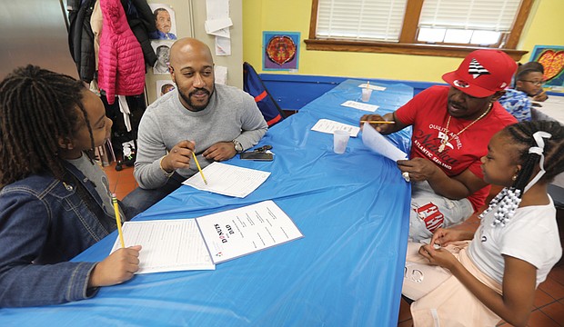 Donuts with Dad, an annual gathering at Richmond’s Barack Obama Elementary School, is a time when dads, big brothers, uncles, grandfathers or father figures participate in activities designed to bridge generations and learning. Antoine Parker, left, joins his daughter, Zaria Parker, 9, and Bravette Johnson, joins his daughter, Shaliya Johnson, 10, for all the fun.