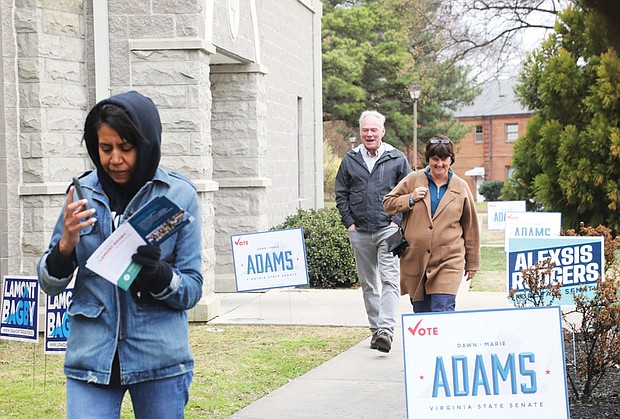 Anne Holton and husband U.S. Sen. Tim Kaine make their way to vote at Virginia Union University on Sunday as Delegate Lamont Bagby’s wife, Jevata Bagby, walks in front of them.