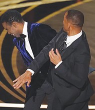 Will Smith, right, hits presenter Chris Rock at the Oscars on Sunday, March 27, 2022, at the Dolby Theatre in Los Angeles. Mr. Rock became the first artist to perform on Netflix live with a global streaming event last Saturday.