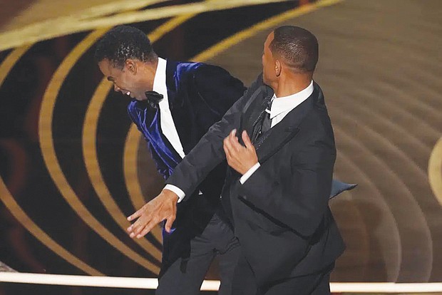 Will Smith, right, hits presenter Chris Rock at the Oscars on Sunday, March 27, 2022, at the Dolby Theatre in Los Angeles. Mr. Rock became the first artist to perform on Netflix live with a global streaming event last Saturday.