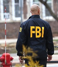 Reported hate crimes in the US increased 11.6% in 2021, according to new data from the FBI, though reporting among agencies remains incomplete. An FBI agent stands outside of Berkey Hall on the campus of Michigan State University on February 16 in East Lansing, Michigan.
Mandatory Credit:	Scott Olson/Getty Images