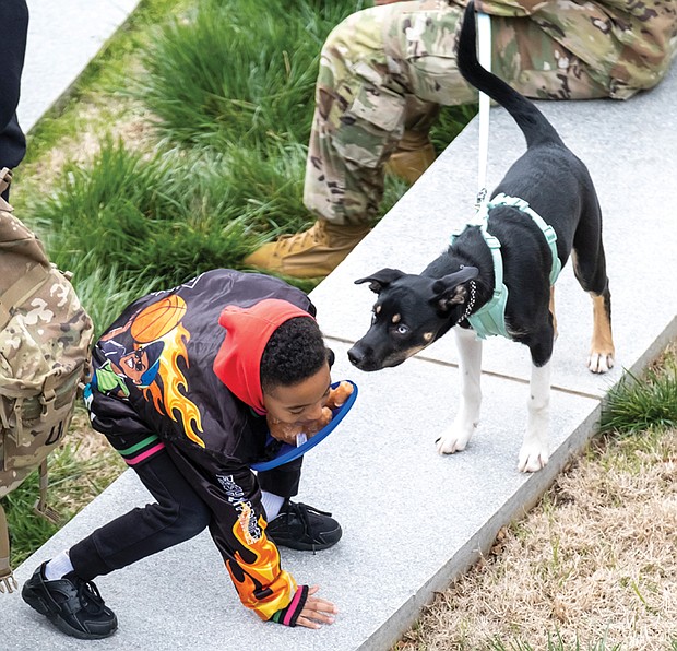 Kyrie Artis, 6, gets acquainted with a dog, along with soldiers from Fort Lee Military Base, during a K9 Walk
at the Virginia War Memorial in Richmond on March 11. The annual K9 event commemorates K-9 Veterans Day in Virginia and across the U.S. The special day recognizes and honors contributions of military and services dogs in battle and to civilian communities.