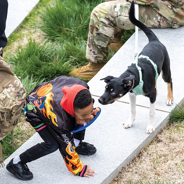 Kyrie Artis, 6, gets acquainted with a dog, along with soldiers from Fort Lee Military Base, during a K9 Walk
at the Virginia War Memorial in Richmond on March 11. The annual K9 event commemorates K-9 Veterans Day in Virginia and across the U.S. The special day recognizes and honors contributions of military and services dogs in battle and to civilian communities.