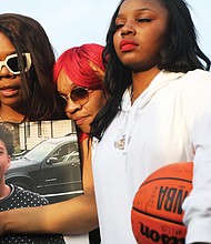Kenyetta Nash, center, mother of Marquan “Quan” Mitchell- Nash, 13, attends a prayer vigil on March 23 held in honor of the seventh-grade Binford Middle School student who was accidentally shot by a family member on March 10. She is supported by her daughters Soliel Mitchell- Nash, 16, and Cherish Hope 18, both John Marshall High School students.
