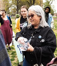 Shannon McKay, (she/her) executive director of He She Ze and We, distributes pins for the Transgender Day of Visibility to make known resources She Ze and We provides for the transgender community and others in need.