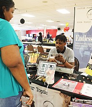 William Davis, a poet based in Grand Rapids, Mich., reads a poem for Andrea Byrd of Richmond during the African-American Book Festival presented by the Virginia Business Expo at Richmond Diversity Center Saturday on April 15.