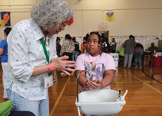 Donna Huang of the City of Richmond Health Department shows Syncere Carter proper handwashing techniques April 22 during the Community Health Fair at Swansboro Elementary School in South Richmond.