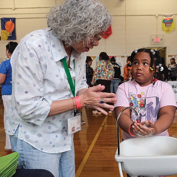 Donna Huang of the City of Richmond Health Department shows Syncere Carter proper handwashing techniques April 22 during the Community Health Fair at Swansboro Elementary School in South Richmond.