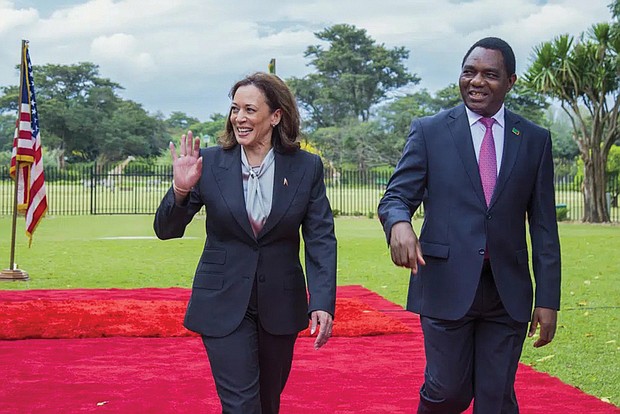 Vice President Kamala Harris, left, walks with Zambian President Hakainde Hichilema on March 31 in Lusaka, Zambia.