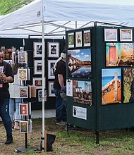 Michael Morris and Shameka Massenburg check out greeting cards by photographer Adam N. Goldsmith Art during the 52nd Annual Arts in the Park event showcasing more than 350 exhibitors from throughout the country. Painting, pottery and ceramics, jewelry, furniture, photography, woodworking, glass, and more were featured during the May 6 event.