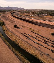 Migrants stand near the border wall after crossing the Rio Bravo river with the intention of turning themselves in to the U.S. Border Patrol agents, as seen from Ciudad Juarez, Mexico, May 9.
Mandatory Credit:	Jose Luis Gonzalez/Reuters