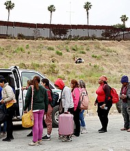 A Border Patrol agent keeps watch as immigrants enter a vehicle to be transported from a makeshift camp on May 13, 2023 in San Diego, California.
Mandatory Credit:	Mario Tama/Getty Images