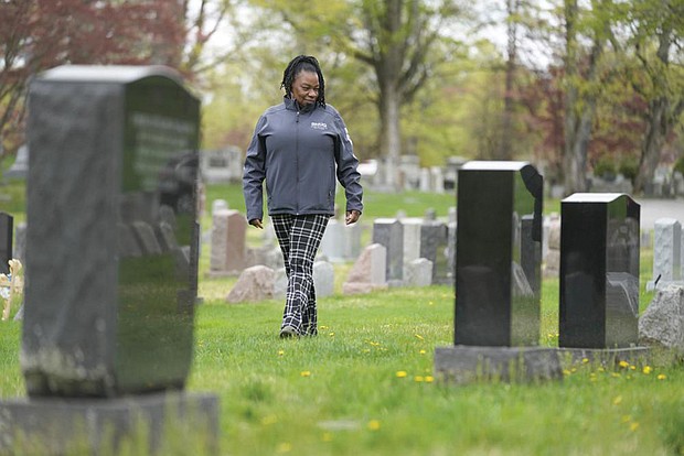 Debra Long walks in April 2023 near the tombstone of her son, Randy Long, in Poughkeepsie, N.Y. An AP examination of data from 23 states shows that Black people are disproportionately denied aid from programs that reimburse victims of violent crime.