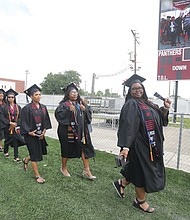 Octavia Davis, 32, above, of Alexandria walks with members of her VUU Class of 2023 during the 124th commencement exercises at VUU’s Hovey Stadium. Ms. Davis is a communications major with a focus in public relations.