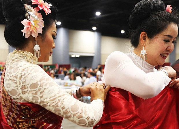 Panida Perez, left, of Amelia County helps her friend Piyamitra Thanasophon of Henrico put finishing touches on their traditional Thai dresses prior to their performance with the NE Thai Folk Dance of Virginia during the 25th Annual Asian American Celebration on May 20, at the Greater Richmond Convention Center. The event was hosted by the nonprofit Asian American Society of Central Virginia Communities, which seeks to advance the integration of Asian Americans into the local community, while maintaining ethnic traditions, culture and identity. Afghan, Bangladesh, Cambodian, Chinese, Filipino, Japanese, Korean, and Vietnamese were among more than a dozen communities celebrating the festive event. In addition to cultural performances, the celebration included heritage exhibits, hands on activities, food vendors, fun, family and friendships.