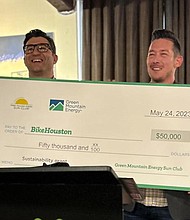 Joe Cutrufo, BikeHouston Executive Director, and Johnny Richardson, Green Mountain Energy Program Manager, smile with a $50,000 Green Mountain Energy Sun Club check for BikeHouston at the Houston Bike Summit Soirée on May 24.