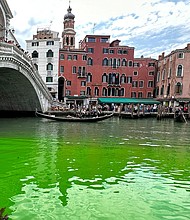 Gondolas navigate by the Rialto Bridge on Venice's historical Grand Canal as a patch of phosphorescent green liquid spreads in it, on May 28.
Mandatory Credit:	Luigii Costantini/AP