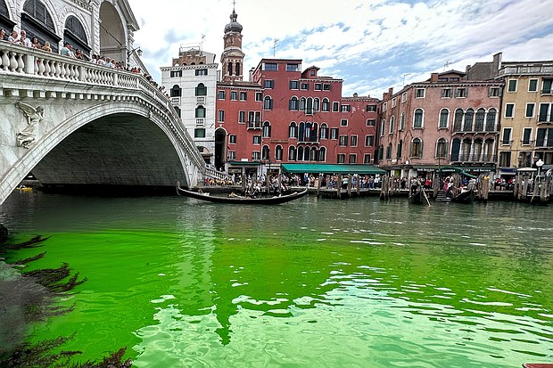 Gondolas navigate by the Rialto Bridge on Venice's historical Grand Canal as a patch of phosphorescent green liquid spreads in it, on May 28.
Mandatory Credit:	Luigii Costantini/AP