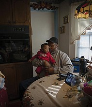 James Lyons kisses his grandson, Adrien Lyons, in the kitchen of his home in Birmingham, Ala., on Saturday, Feb. 5, 2022.