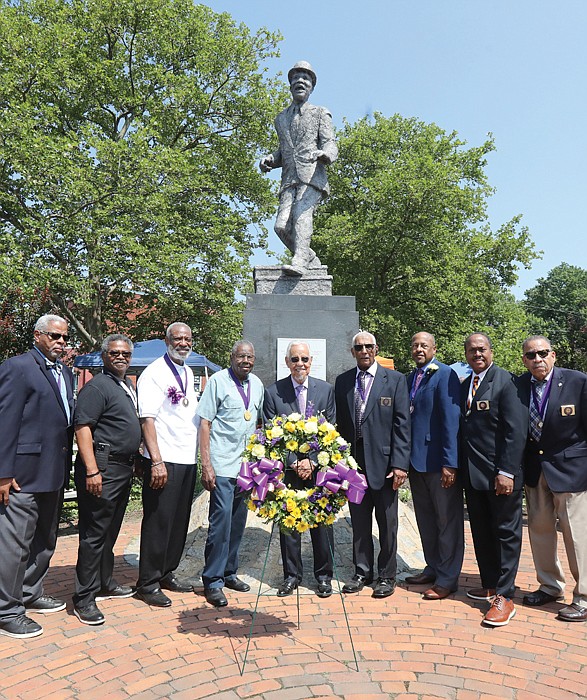 Former Gov. L. Douglas Wilder, center, stands with members of the Astoria Beneficial Club and others gathered to recognize the 50th anniversary of the installation of a statue honoring the late Bill “Bojangles” Robinson.