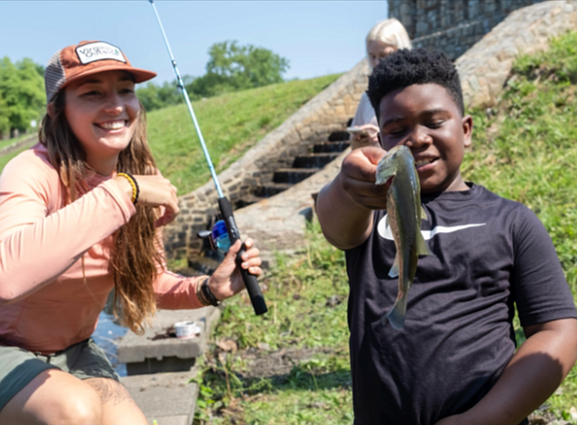 The Richmond Department of Parks, Recreations and Community Facilities went fishing June 3 by hosting the Family Fishing Fair on Shields Lake in Bryd Park. Brittany Deleon, project manager of Virginia Outside, left helped Travis Garrison, 9, unhook a big mouth bass that he caught on the scenic lake in Richmond’s West End.