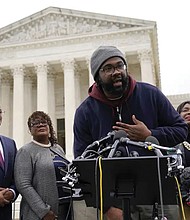 Evan Milligan, center, plaintiff in Merrill v. Milligan, an Alabama redistricting case that could have far-reaching effects on minority voting power across the United States, speaks in October 2022 with reporters following oral arguments at the Supreme Court in Washington. Standing behind Mr. Milligan are his counsel Deuel Ross, from left, Letetia Jackson, Rep. Terri Sewell, D-Ala., and Janai Nelson, president and director-counsel of the NAACP Legal Defense Fund.
