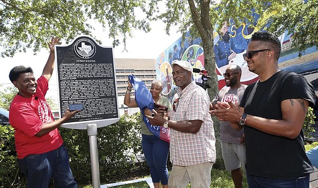 Sam Collins III, left, and others celebrate at the Juneteenth historical marker on June 17, 2021, in Galveston, Texas, after President Biden signed the Juneteenth National Independence Day Act into law. Communities all over the country will be marking Juneteenth, the day that enslaved Black Americans learned they were free. Yet, the U.S. government was slow to embrace the holiday.