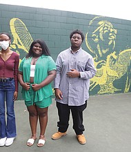 Local muralist Jake Van Yahres, back right, along with three young Richmond artists, Jordan Felder, 16, left, Leah Johnson, 15, and Jay Campbell, 16, join Richmond Parks and Recreation Director Chris Frelke and other parks and recreation staff for the grand reveal June 9 of a mural they created with tennis balls on what was once just a backboard for practice. It is now transformed into another celebration of the life of local hero Arthur Ashe at Battery Park on Richmond’s North Side.