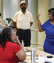 Lashrecse Aird, right, talks with poll workers while visiting a polling precinct Tuesday in Surry, Va. Ms. Aird won her bid to unseat Virginia State Sen. Joe Morrissey in a Democratic primary for the newly redrawn 13th Senate District.