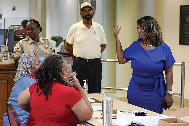 Lashrecse Aird, right, talks with poll workers while visiting a polling precinct Tuesday in Surry, Va. Ms. Aird won her bid to unseat Virginia State Sen. Joe Morrissey in a Democratic primary for the newly redrawn 13th Senate District.