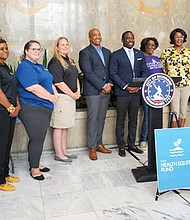 Saraya Perry, far left, program officer for the Health Equity Fund, stands with the latest HEF partners on Tuesday in Richmond City Hall Tuesday afternoon. They are joined by Mayor Levar M. Stoney (sixth from right) and Richmond City Council President Michael Jones (seventh from right).