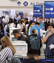 Travelers wait in line at the departure area check-in at the United Airlines terminal at Los Angeles International airport, Wednesday, June 28.
Mandatory Credit:	Damian Dovarganes/AP