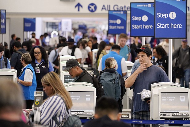 Travelers wait in line at the departure area check-in at the United Airlines terminal at Los Angeles International airport, Wednesday, June 28.
Mandatory Credit:	Damian Dovarganes/AP